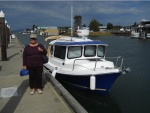 Betty and Our Marinaut at La Conner.  Please take a look at the front, starboard window.  It is so wide, that I can easily hang out the window to set the midships fender and docking line to the dock cleat.  It's not just my arm -- I can comfortably hang the entire upper part of my body out the window to set the line and fender.  This has greatly made docking easier.  What a great design!

Shown also are the privacy, snap-on canvas curtains in the front windows