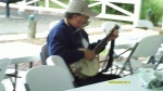 Tom McHugh playing banjo and harmonica