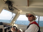 Fin at the helm in the ocean (huge tanker in background).