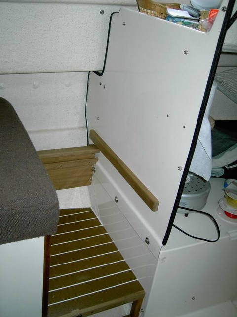 Seat moved aft. Wooden bumper installed on bulkhead keeps seat box from rubbing on bolt heads below. Bin front end is in center of photo.