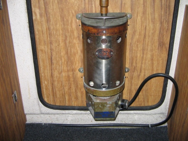Propane Force 10 heater mounted on inside of door.  Propane hose goes down along water hose, thru cabinet and out into cockpit shelf.