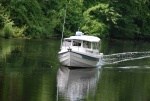 Steve and Joan of OSPREY approaches the dock under the watchful eye of grandson, Henry, at the mate's seat.