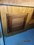 A close up of the louvered door installed under the port side aft seat.