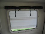 Roll up and tie window curtains.  Held down with Velcro tabs.