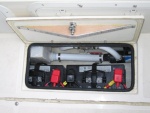 Batteries are installed below the deck hatches to keep weight low and free up storage space in transom - house bank shown.  Solenoid operated battery switches are remotely controlled from the helm station.  Truss mounted to underside of deck hatch improves seal by  preventing ends of hatch from springing upwards.  The truss is designed to bend the ends of the hatch downward about 1/16
