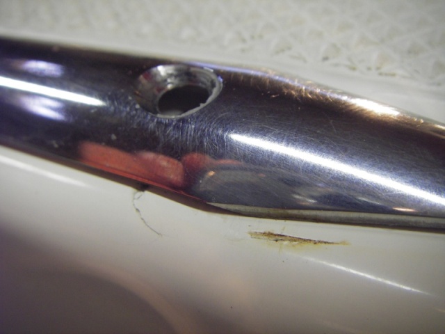 Screw removed and SS piece moved to show gel coat crack and wear spot needing repair on port gunnel top plate.
