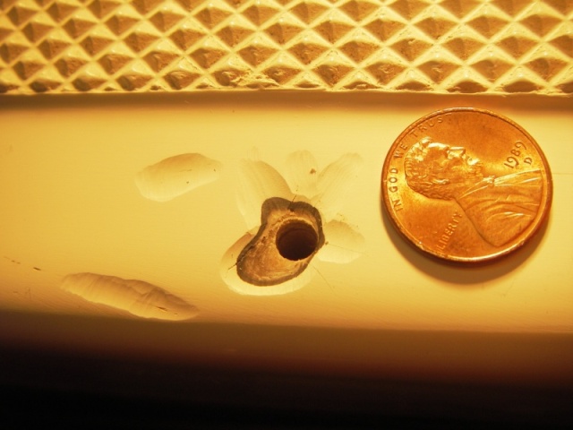 Penny for scale, showing grinding done to take out cracks in gel coat,  from screws moving and SS step guard digging into it.