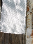 12 oz biaxial cloth. Fibers oriented at 45 degrees, mat under for adhesion