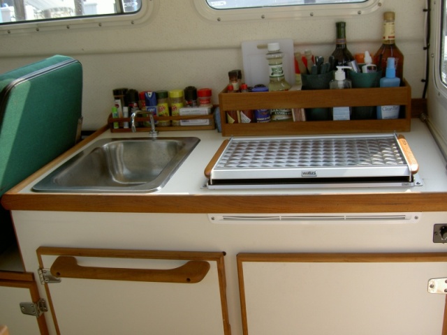 Galley: teak racks and towel bar.  Note forward position of stove.  We specified this when ordering so we would have space behind for storage.  It seems that most stoves are mounted too far back.