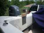 cockpit side view. Used contact cement and a pleated  white garbage bag on the inside of the mount it just sides down over the motor wells transom. The bare aluminum left black marks on Will-C. No marks now it just slides on or off when we need to carry the dink motor. Our slant back canvas still fits with the dink motor bracket in place.