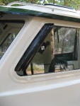 Vent visor installed on sliding windows-- cut down from generic car visor (a Bronco model, I think). $40 for a pair.