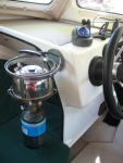 Forespar Mini Galley gimballed propane stove with kettle mounted next to helm; provides heat in a pinch