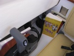 The space between the helm seat and galley cabinet, and right of throttle, is great for books and maps