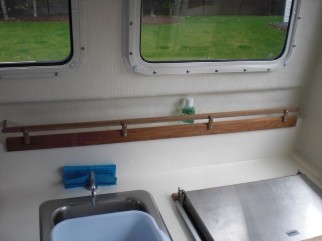 Fiddle rail added to galley shelf.