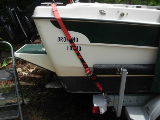 The boat came with two straps that went from the same eye hook on the trailer frame to eye bolts on the bak of the boat at the same elevation as my home port Orofino.  It did not seem to me they would do much to hold the boat on the trailer in a big highway bump, so I went to the clete as shown.  I considered a strap that would wrap across the whole cockpit from one side to the other with just one large winch. I rejected that because using the boat for camping (boater-homing