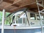 Exterior view of AC. Exterior panel above AC is cut to the same size as the original window and painted white. A cover for the AC will be made in the future. View of the shelter, constructed for a previously owned pontoon boat did not allow enough overhead clearance to consider a roof top AC. 