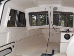 Once dry, it gets sprayed with an off white paint that is fairly close to the gel coat color.  The surface of the rubber paint would attract too much dirt.  Notice the black conduit hanging down.  Black wiring was strung all around the boat.  I can fix that.