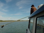 Poling boat with motors up in shallow water entering Lake Labarge