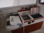 Galley - sink, Wallas diesel cooktop/heater w/small black control, Stbd interior window shade, Vessel Sys DC Monitor VSM 422 in front of sink