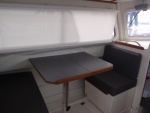 Dinette w/Nav seat facing aft, table up, storage in sliding box below and under floor