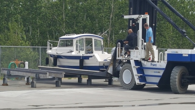 Brand new forklift driver picking up the brand new boat from the work stand.  The experienced driver there for support.