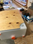 Tank upside down on workbench with platform cutout.