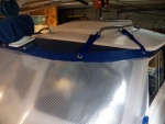 It is held on the cabin lip by Dot Common Sense fasteners in the center and webbing clips on the wings.