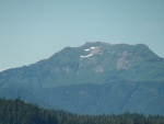 Melting snow leaving smiley face on mountain, Gambier Bay