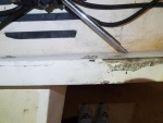 Transom under trim strip shows damage and evidence of past repair. The black plastic strip was missing and a previous owner tried to seal the evident junction between core and fiberglass with epoxy.