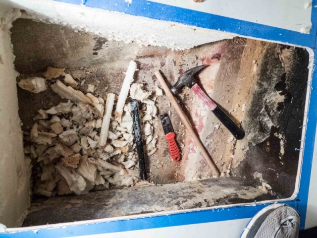 I used a metal pipe with one end sharpened as a coring tool to remove the foam under the portable toilet storage area. The wooden dowel is used to push the foam core plugs out of the pipe. The end goal was a tunnel that passes under the inspection hole and to the other side, just forward of the cored hull bottom, for battery cables to pass through.