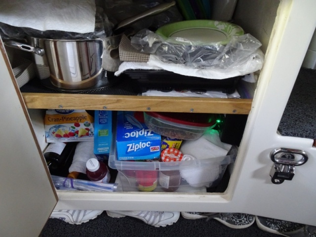 Storage where the water heater was removed.  New water heater is under the galley and behind the sink.  The hinged step is for some people to get onto the dinette.  The dinette has a second set of cushions to make it into a settee, with a back facing inward.  The induction burner is here for storage when underway.