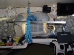 spreader bar in position to. hoist air conditioner.  The outer carabiners are used for hoisting the dinghy, the inner D shackles go over the handles of the window AC unit.  The shelf above has two pieces of 1 1/2