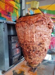 Thin layers of marinated pork stacked on a spit then slowly rotated in front of the flames, then thinly sliced off for \