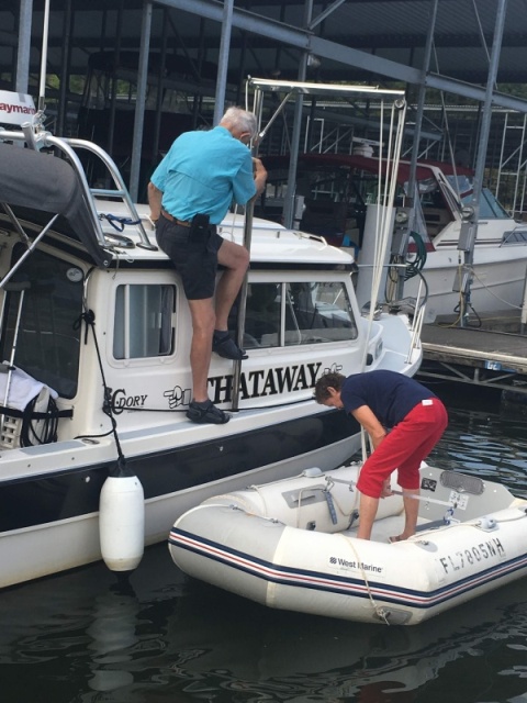 Ready to lift, Marie will come aboard into the cockpit and then go forward to help guide the dinghy onto the top.  The dinghy is hoisted bow aft, so the tubes will go under the radar arch, as it is rotated over the top of the boat with the davit. 