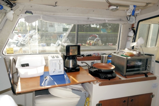 Galley extension over helm seat with 110AC outlet freed up after removing water heater and getting more storage cabinet space