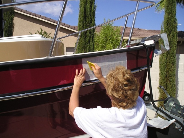 Marilyn smoothing out the surface after soapy water solution applied to letters and boat surface