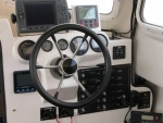 The 2 smaller guages above the helm are HONDA H2O press. gauges. Small switch above LENCO Trim Tab Control Panel is the winch control switch with the circuit breaker located to the right of the hand mic., above the VHF radio. The plastic hub has since been replaced with a beautiful piece of teak.