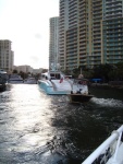 Aft view of Retro boat under tow through river. Big boats frequently use tugs for liability reasons.