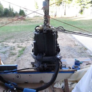 Another view of the engine hoisted.  The lines going off to port go to the stern cleat on that side and hold engine slightly to port, while I do starboard side holes.  Next I'll hold engine slightly to starboard and do port side holes.