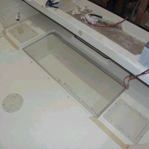 Media 'View of fish box (lid removed) and side storage areas (these access lids were too small and are to be replaced with larger units).  Les thinks that maybe the batteries might fit below deck in these areas (that's Les, always thinking).  A close examination reveals the macerator pick-up tube (near side of box).' in album 'Jerry And Helen's New 25. Cream exterior and nonskid with Nomad accent. Interior fabric will be Taupe. (All Photos Courtesy Of Les Lampman - Thanks Les)!  3/8/04'