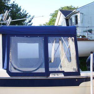 Notice level roof no step up. Windows and cabin roof are taller on the 23' Ventures. The top carries the boats curved roof contour. Where the canvas attaches to the boat the canvas has a slide in track plus a velcro seal and a zipper for easy removal. All the bows have zippers for easy on and off. The frame has quick disconnect pins that are tethered to the gunnel mounts.