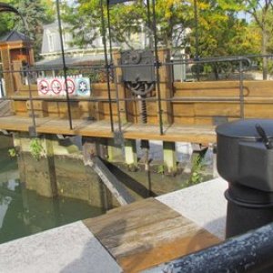 Hand cranked doors and flood gates. The round thing with a lever is the part they put a crank handle on to crank the lock doors open or closed a separate unit for each of the two gates. The exposed gear is the gate that controls the water