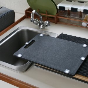 Media 'Pads glued on to keep the cutting board in place while underway' in album 'Inspired by others - galley rack made with 2 1/2" wide oak with two 3/8" dowels running the length.'