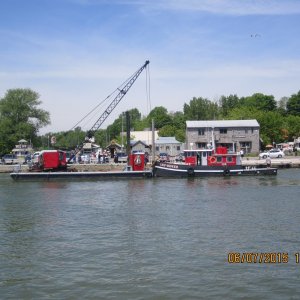 The tug towed it up the river with the mast strapped to the side of the barge where it could rest a while to make sure it was waterlogged before being dropped to the bottom of the lake again.
