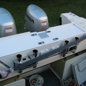 (Not For Hire) Anti-poop barrier board?and fishing shelf. Hinged access to fenders. Downrigger mount in center for third downrigger (need long boom for this one "down the chute." Downrigger mount reinforced with stainless rail beneath shelf.