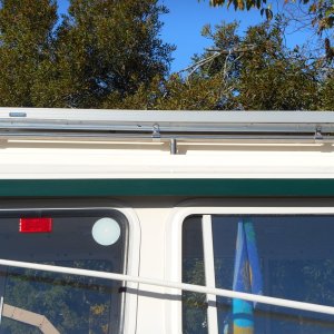 Media 'Six clips mount frame to original hand rails.' in album 'I used this idea for several years and realized 200 watts was overkill for me.  I remounted one 100 watt panel on standoffs on the middle of the roof.  This clears the hand rails and looks neater.'