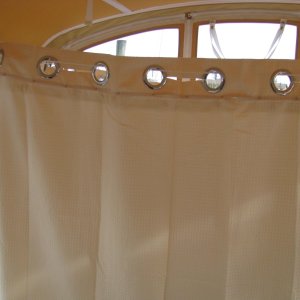 03 Marinaut 215 cockpit temporary portable toilet enclosure view from cabin looking out toward the stern.  We got these curtains from Bed, Bath and Beyond.  They are very easily to attach with the built-in curtain ring system.  They originally had a 1+ foot top sheer, which we removed, and binded the top and bottom pieces together using 1/8" diameter x 1/4" long aluminum pop rivets (with 1/8" aluminum washer backing.)  This worked well, because in their 6 foot long original form, the curtains were too long.  At 5 feet long, the curtains are now, for us, a perfect length.  Incidentally, we used a total of 3 curtains, each one costing $20.  Also, each curtain has an inner liner.