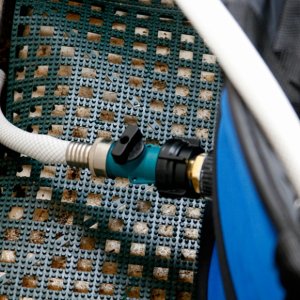 Media 'An ordinary garden hose coupling and cutoff valve is plumbed into the collapsible tub drain. The hose empties into the mid ships bilge and 1100 gph bilge pump empties the water overboard.' in album 'Heat Exchanger is constructed using 25 ft of 3/8 copper tubing coils. The coils are submerged in a pot of water which is heated on the Wallas. THe water hoses are attached to the coil using quick connect fittings. Hoses are stowed out of sight behind the starboard seat cushion for quick deployment.'