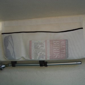 Storage pocket in V-berth, port. Made of heavy polyester mesh, with black double-fold bias binding trim.  Velcro glued to wall holds the pocket.