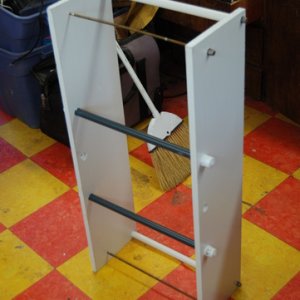 Cooler holder for rack.
Used 2 36" x 1/4 brass threaded rodsfrom H.D. (each cut in half to make 4. Used 1/4 SS cap nuts on front 1/4 ss nylock nuts on back.
Used 1/2" sced. 40 PVC as top seperator.
Drilled a couple 7/8" holes in the bottom and used 18"x1/2 threaded PVC risers with twist on caps (spaced and located so they can be placed through any 2 rungs on the ladder/rack, so that cooler can be placed anywhere on rack to maximize boat balance and or rear view. I used 7/8" wood (just because I had it) 1/2" starboard would likely be more durable but this will last a long time. May need to notch for the spring latch so that it can fit far left.